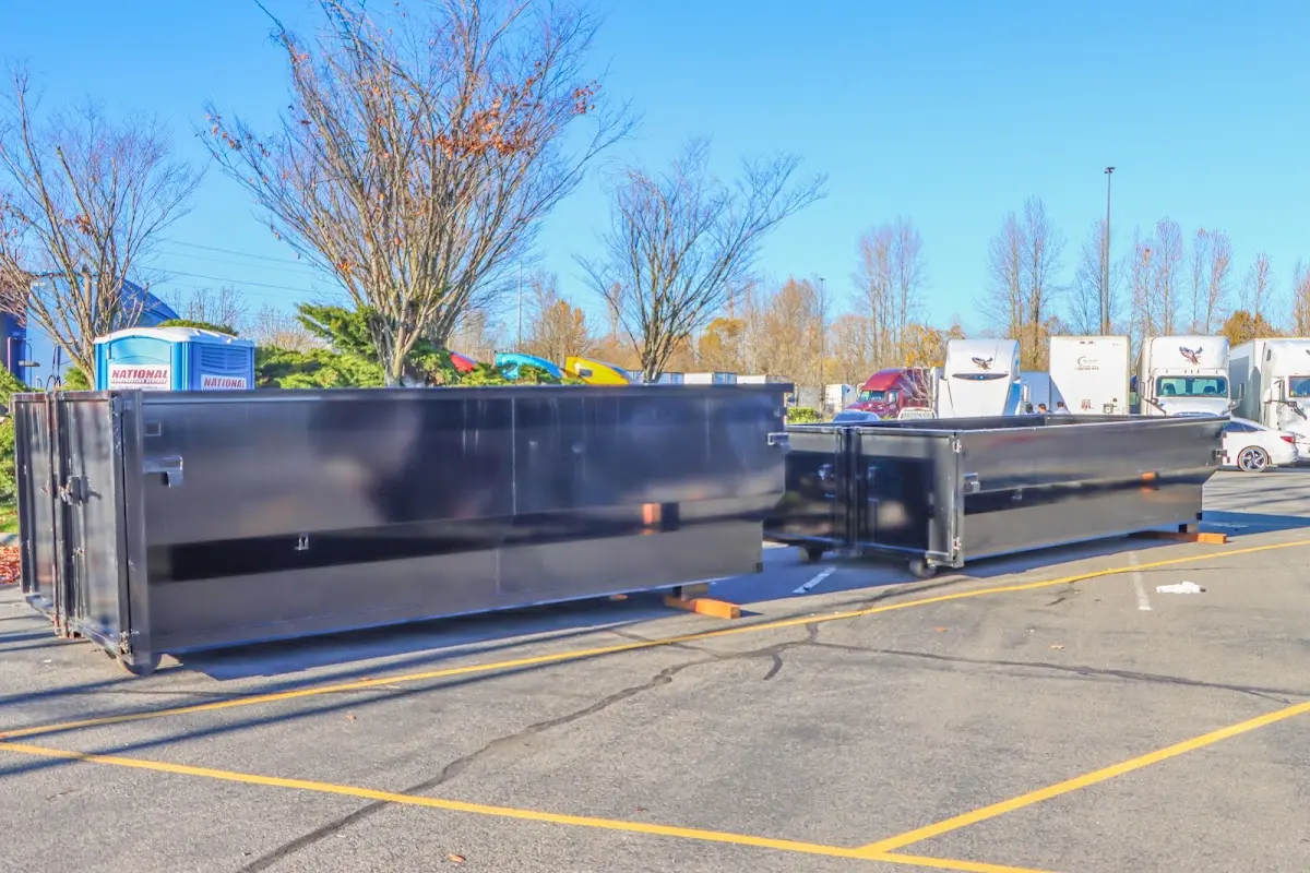 Professional dumpster rental service with roll-off container on residential driveway in Baxter Village